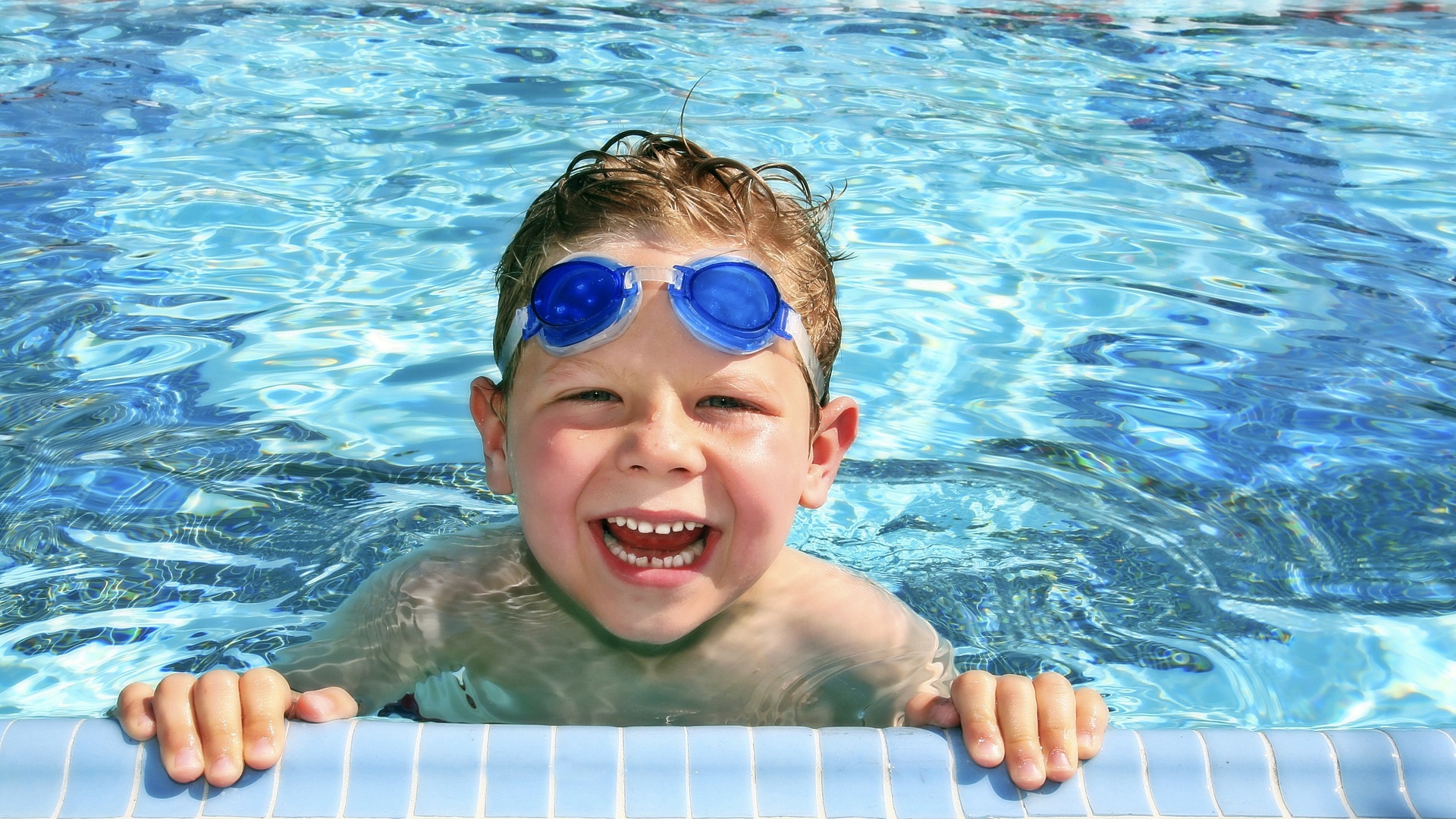 Мальчик плавает в бассейне