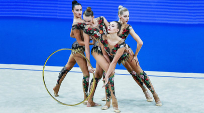 Спортсменки сборной России выполняют упражнения с обручем в групповом многоборье 