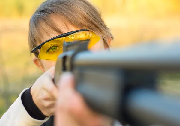 Young beautiful girl with a shotgun — стоковое фото