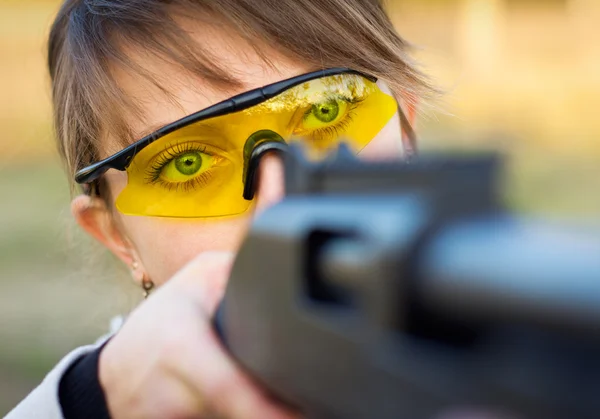 Молодая девушка с оружием для ловушки стреляющие и стреляющие очки — стоковое фото