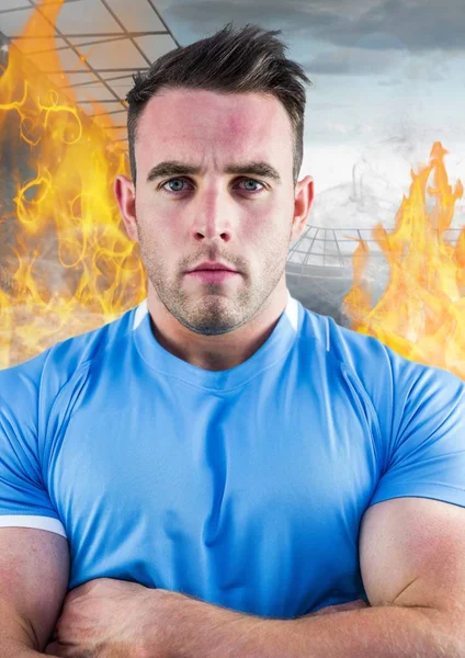 Спортсмен, стоя с руками, скрещенными против пожара в фоновом режиме — стоковое фото