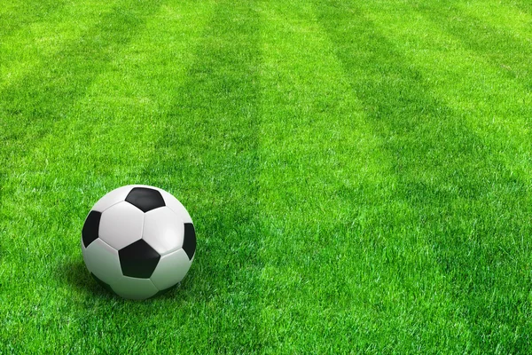 Зеленый Полосатый футбольное поле с футбольным мячом — стоковое фото