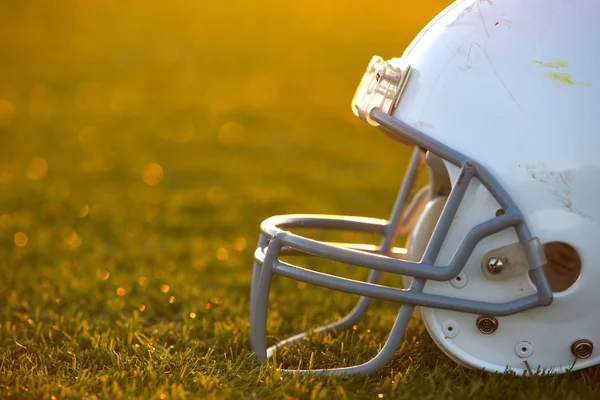 Американский футбол шлем на поле с подсветкой — стоковое фото